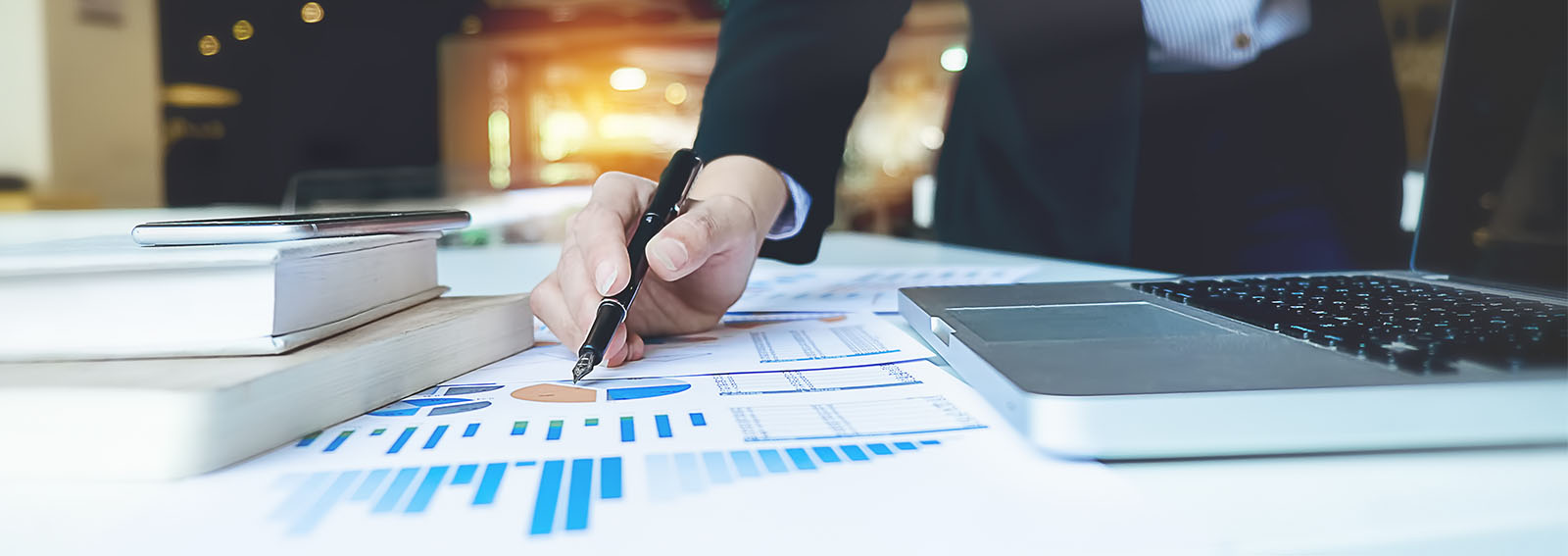 Business person points to a graph on a table with a pen.