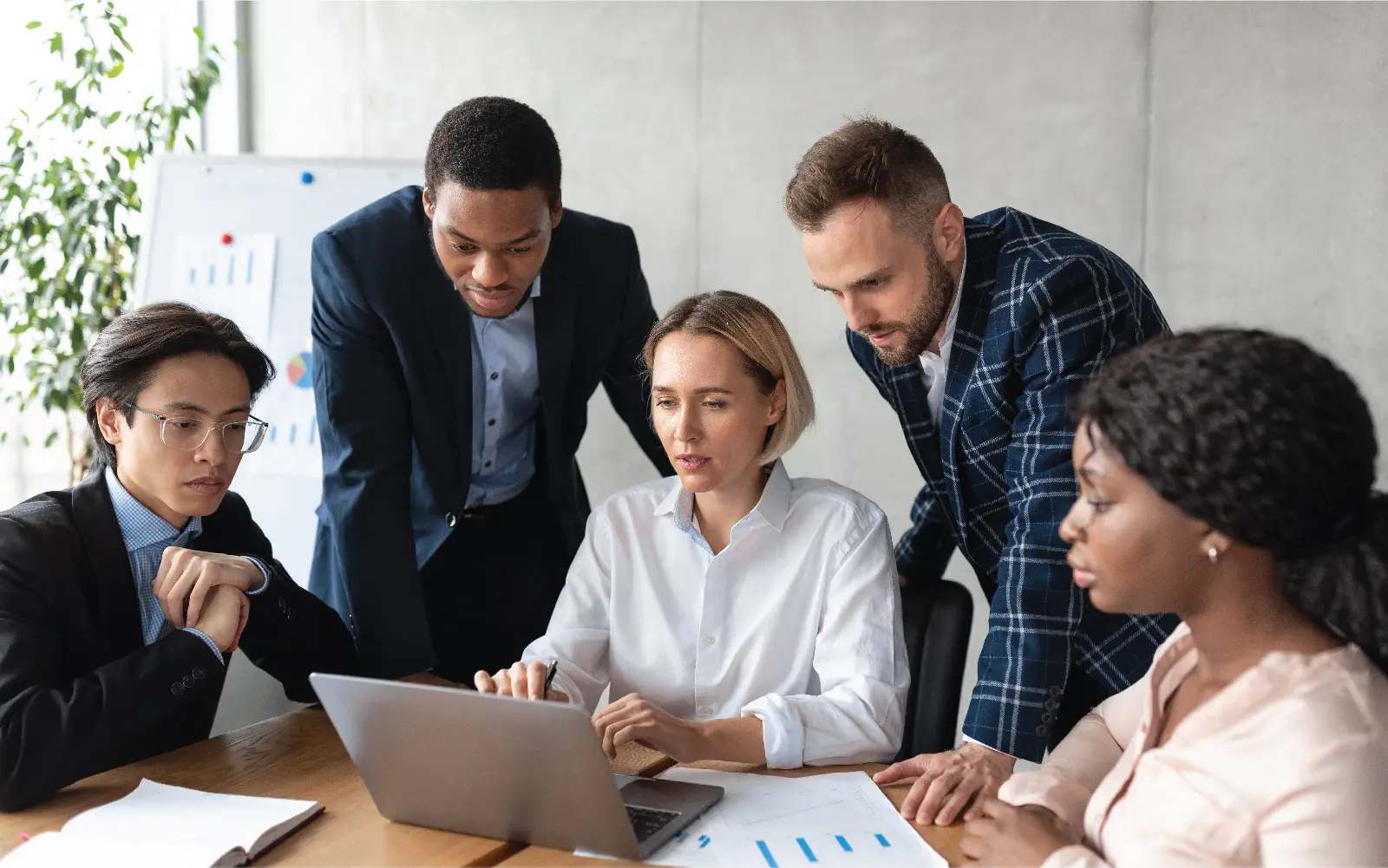 5 people working around a laptop