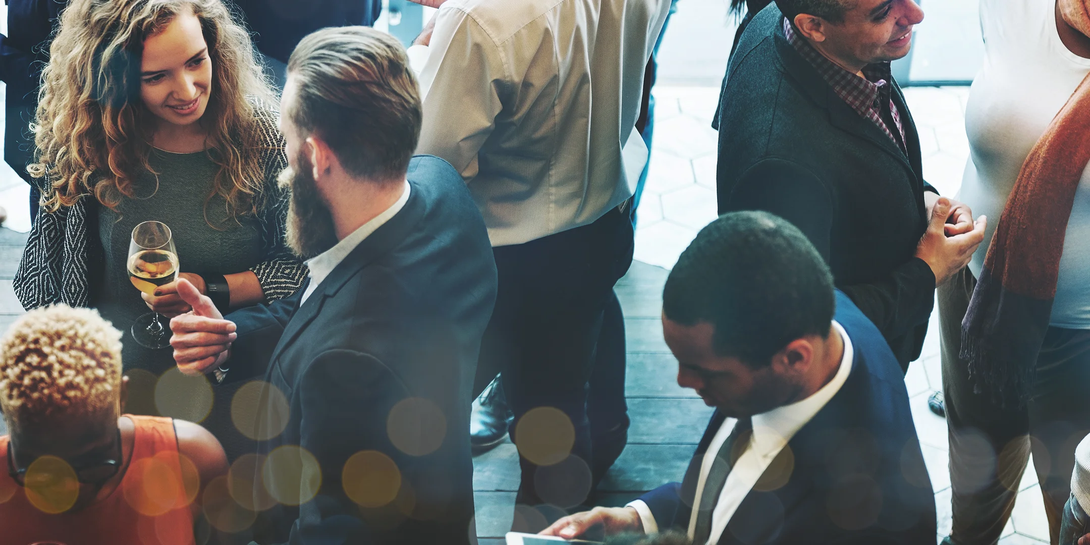 A group of professionals drinking wine and conversing at a networking event 