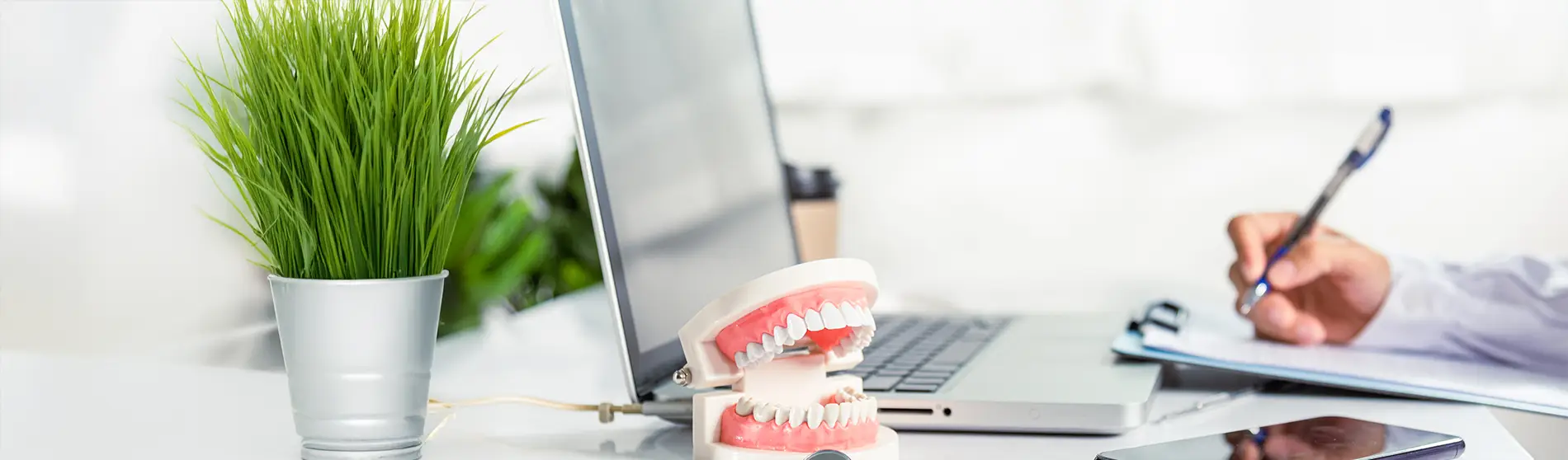 Desk at a dental office with a dentist filling out paperwork