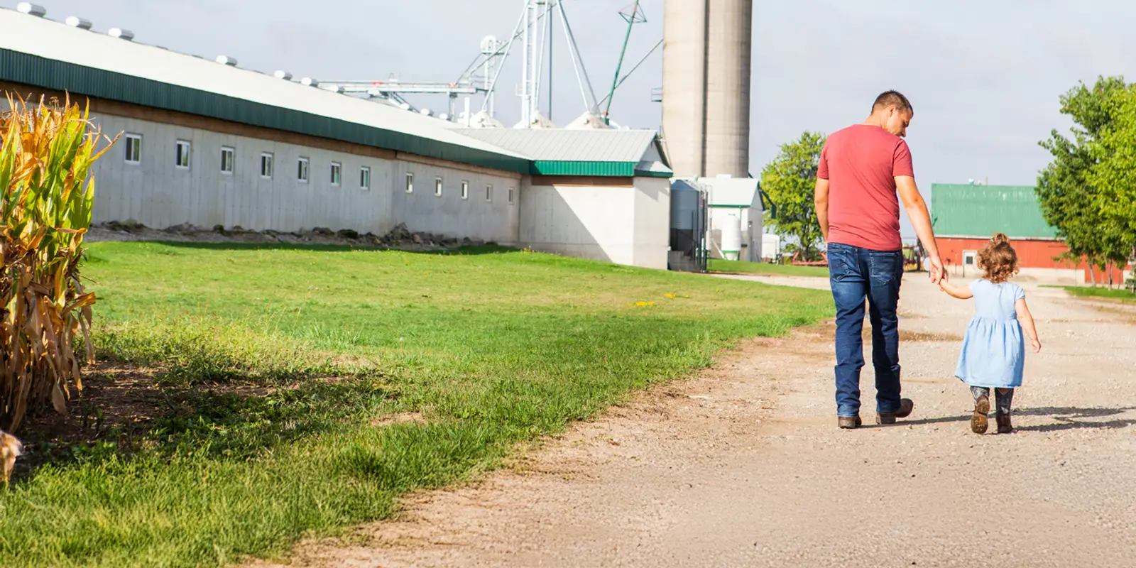 Young farmer walking on the farm with his daughter