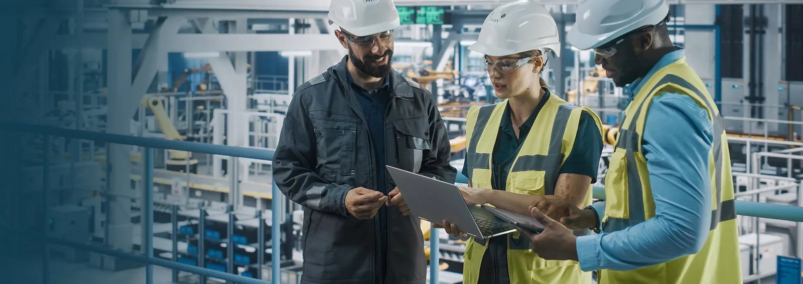 Travailleurs de la fabrication examinant des documents sur un ordinateur portable