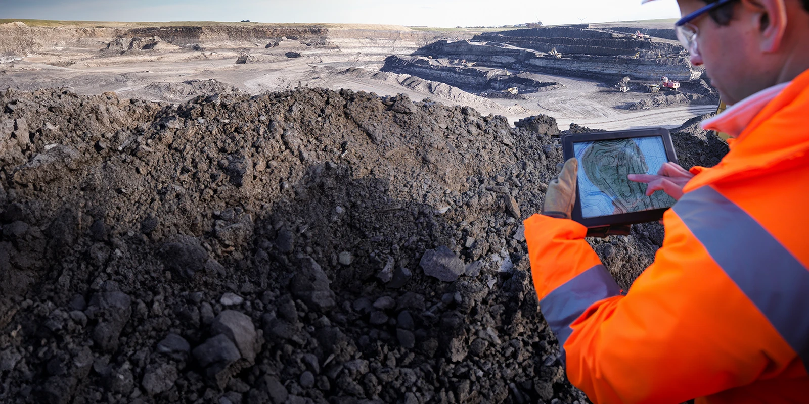 Ecologist using a tablet surveying surface coal mine site