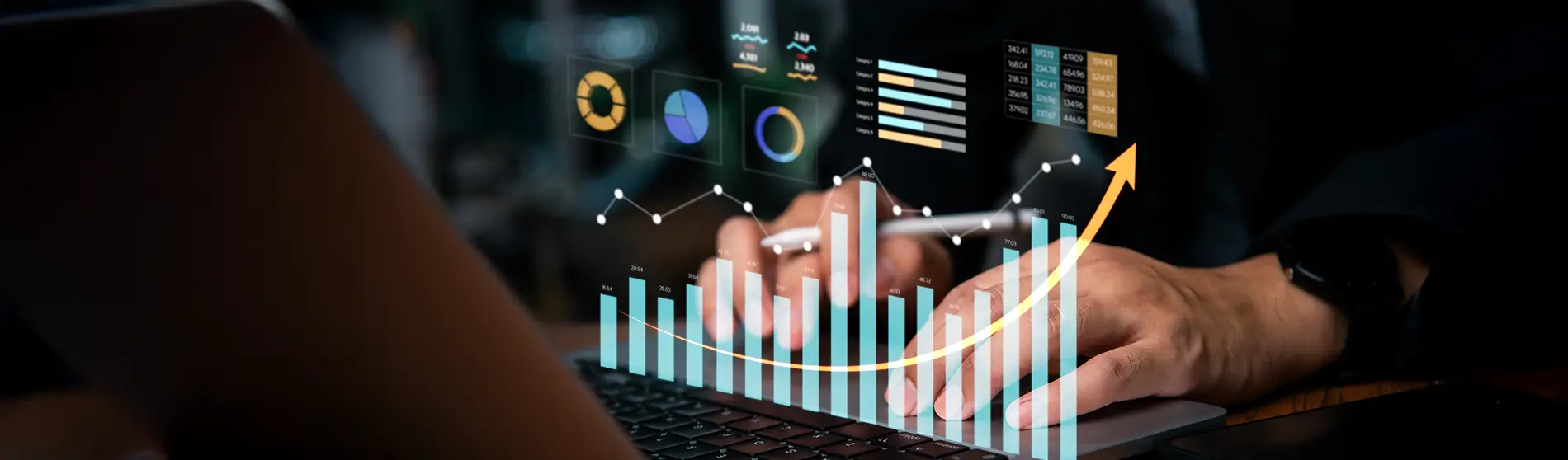 Man typing on laptop with virtually overlayed graphs