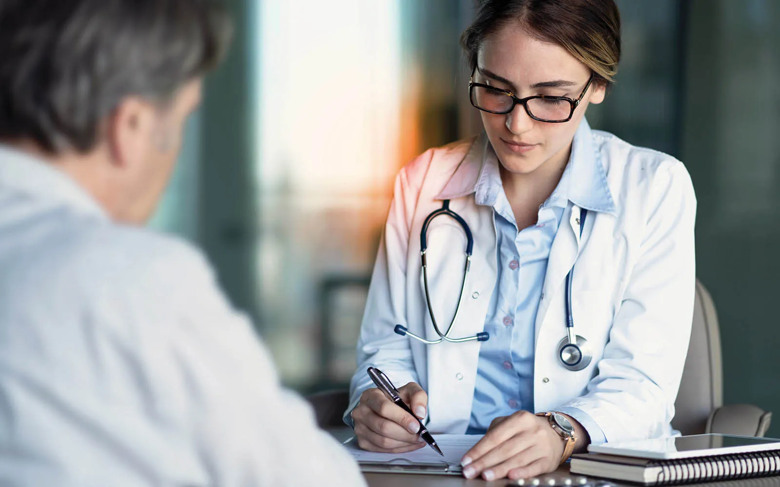 A doctor sitting with a patient 