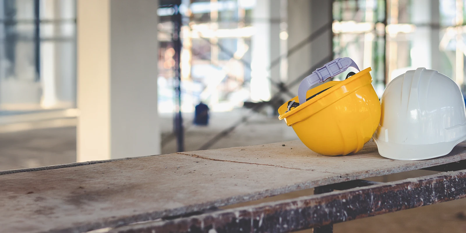 two hard hats on a table in a construction site