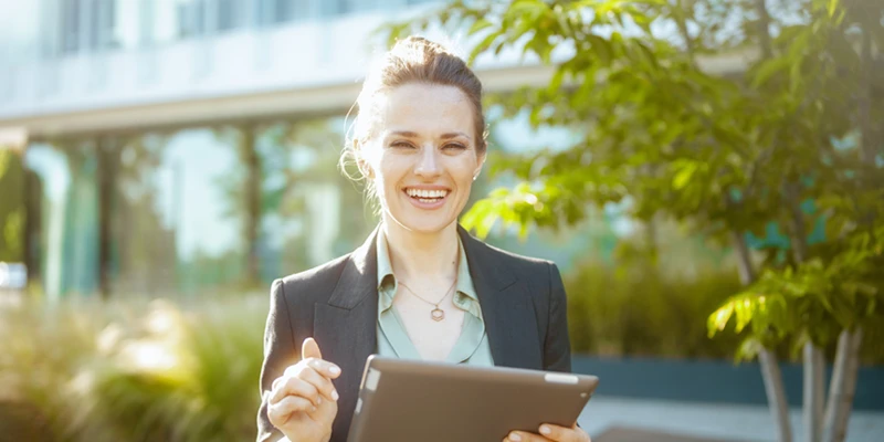 Femme debout dehors avec un iPad à la main