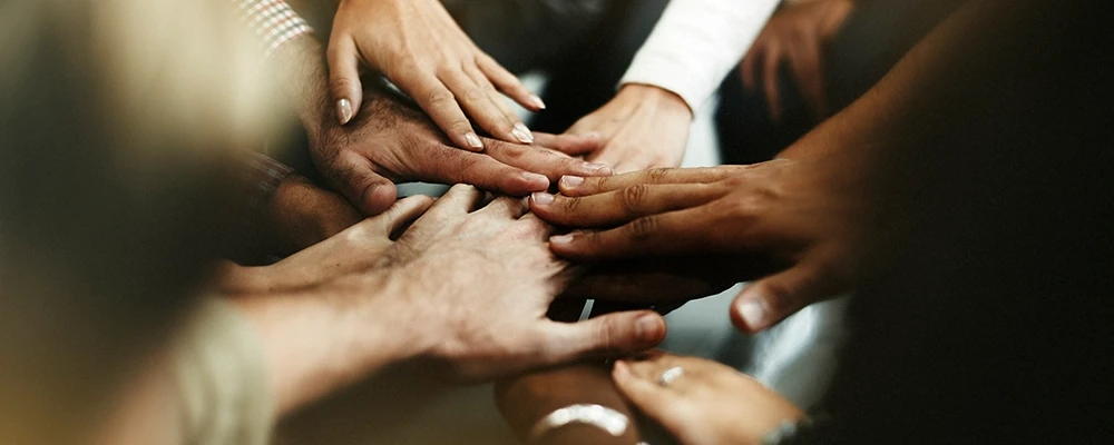 Groupe de mains de personnes réunies en cercle