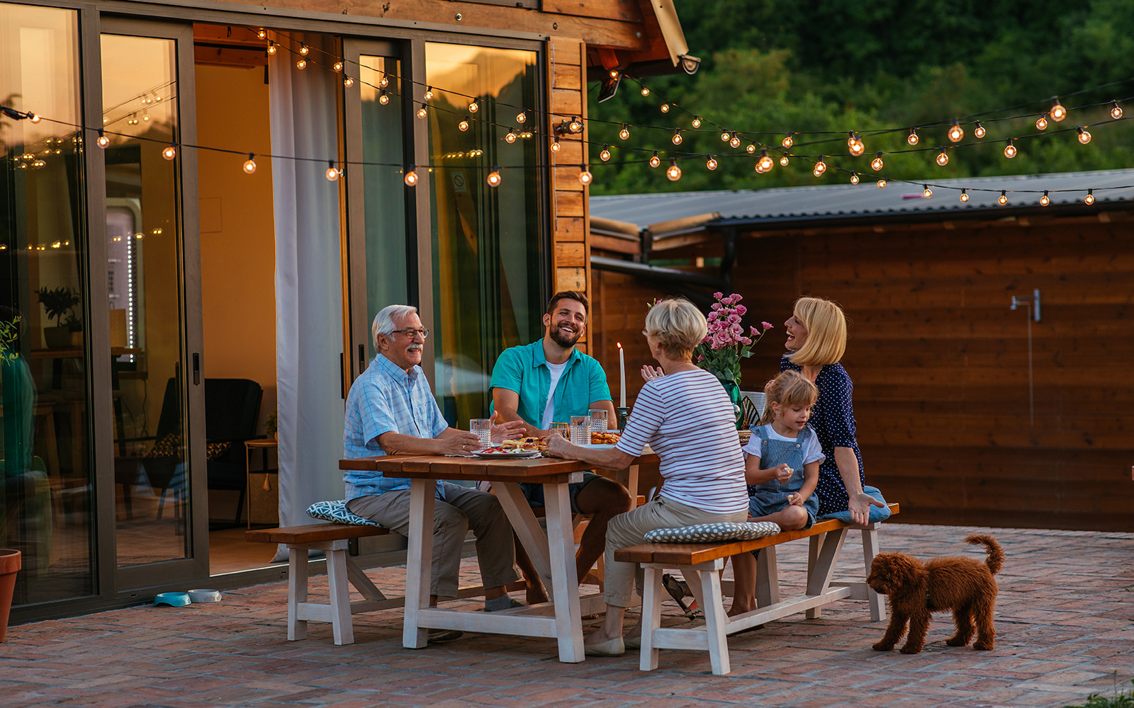 Happy cheerful family enjoying meal together in garden