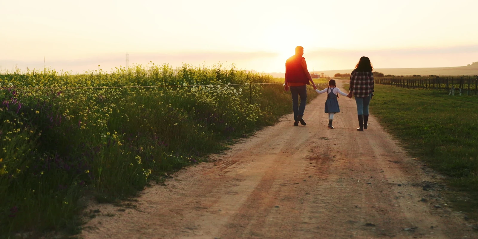 farm family walking down a dirt road in the evening