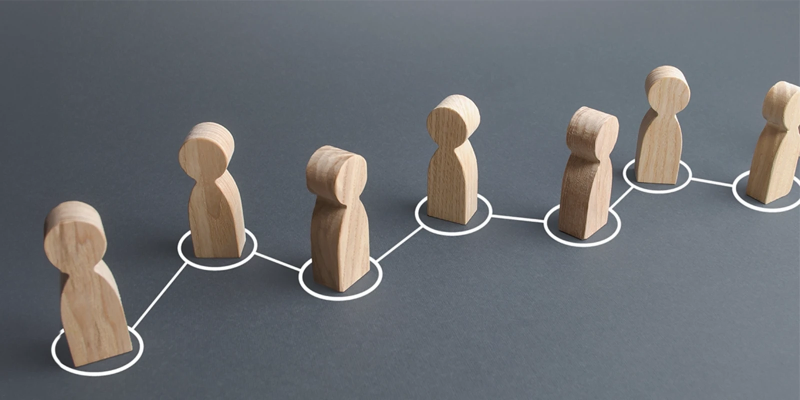 Wooden figures connected by white lines and circles on a gray background