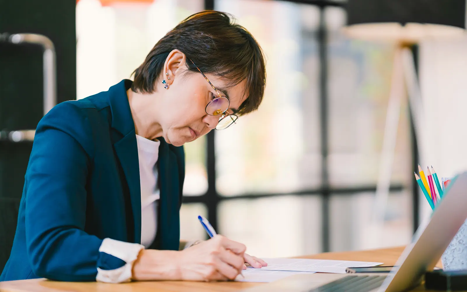 Person working at a desk writing something down 