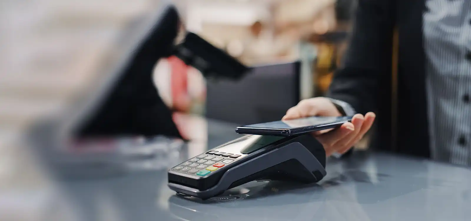 Femme payant au magasin de détail avec son téléphone intelligent