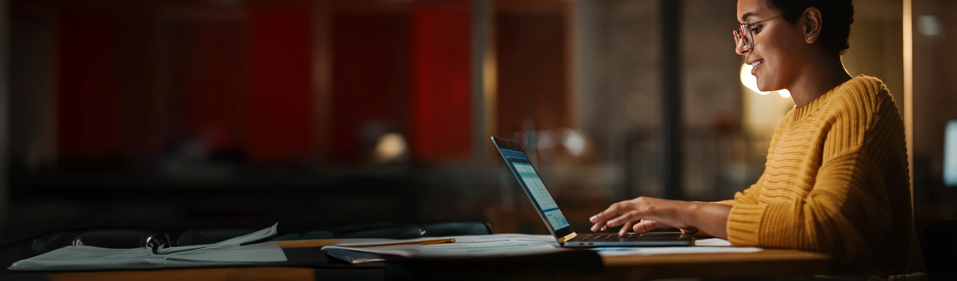 Business woman reveiwing financial reports on a laptop