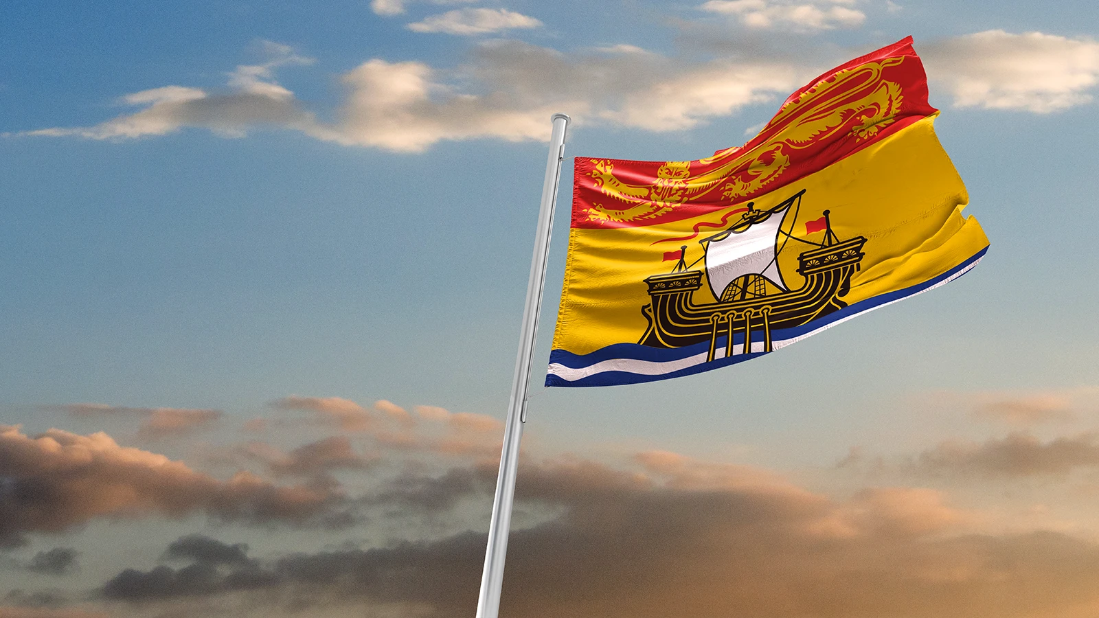 Le drapeau du Nouveau-Brunswick flotte au vent au coucher du soleil